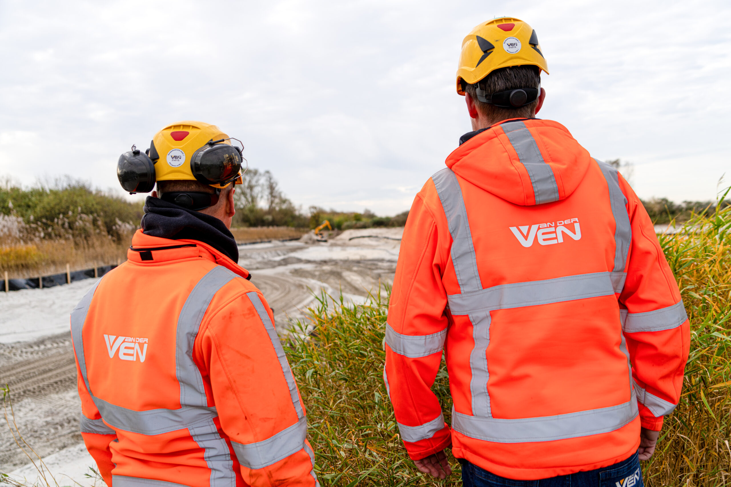 Twee medewerkers van Van der Ven kijken uit over het werkterrein in Berkheide
